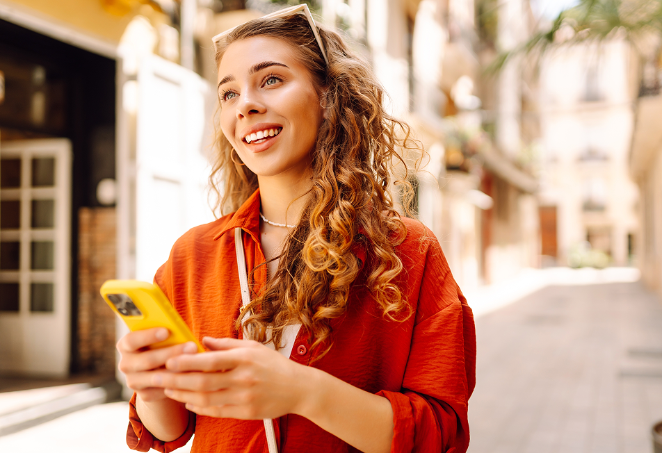 Ragazza sorridente con lo smartphone in mano